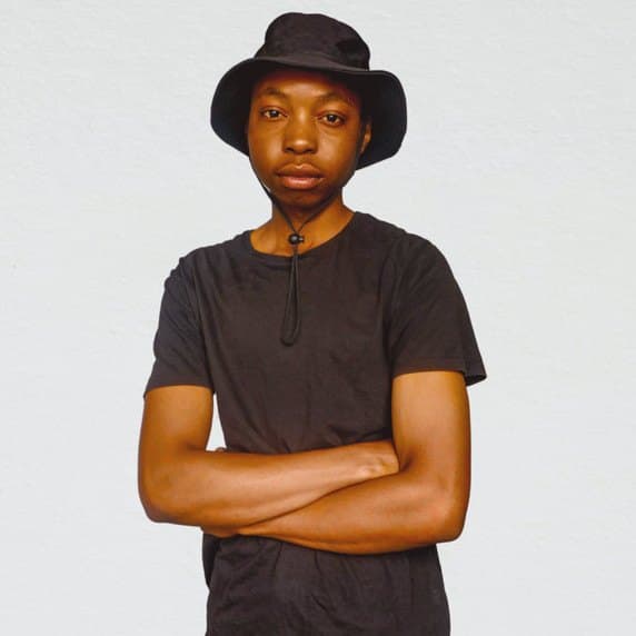 Takue SBT in a black bucket hat, arms crossed